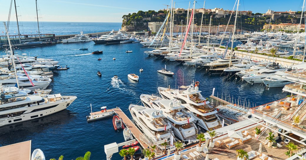 Elevated aft view of Port Hercule at Monaco Yacht Show, numerous yachts moored overlooking sea