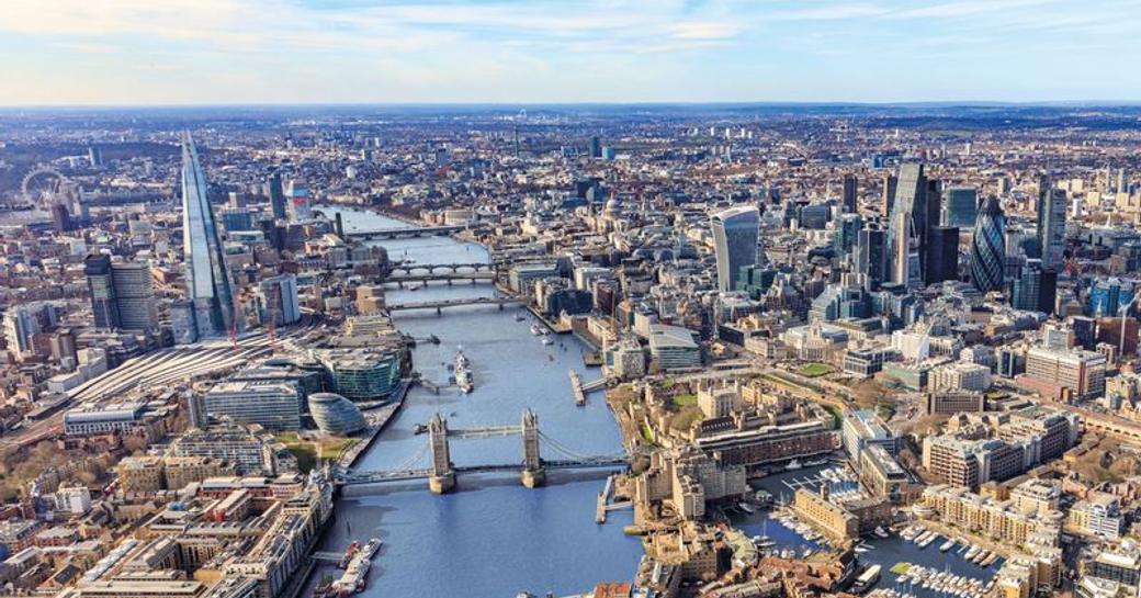 Aerial view of St Katharine Docks London, multiple motoryachts and sailing boats docked, surrounded by marina facilities and London streets