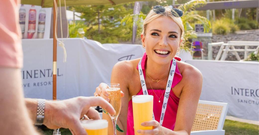 A visitor to the Sanctuary Cove International Boat Show wearing a VIP lanyard enjoying drinks