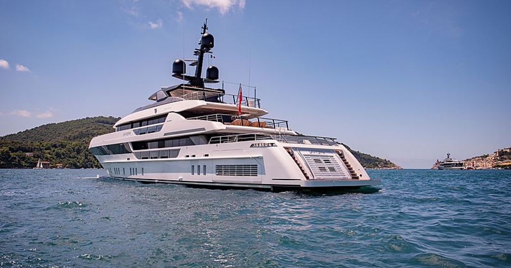 Rear view of Sanlorenzo Lady Lena underway, surrounded by sea and elevated terrain in the background