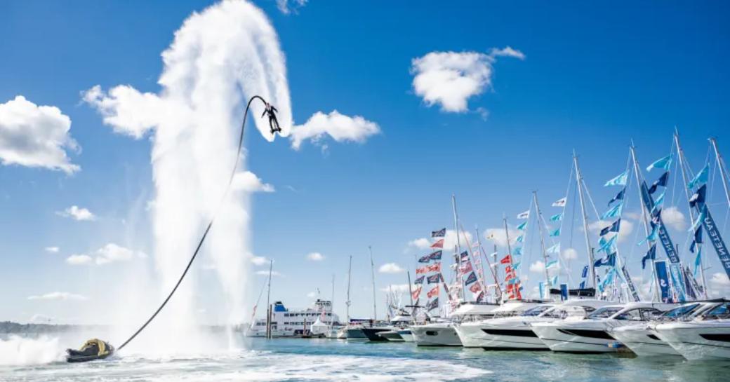 Flyboarding demonstration at Southampton Boat Show, motor yachts moored in background. 