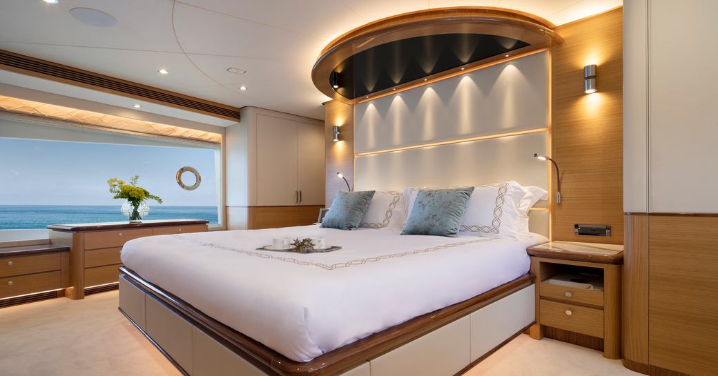 Master stateroom on Crowned Eagle with large bed and lighting in ceiling and large window