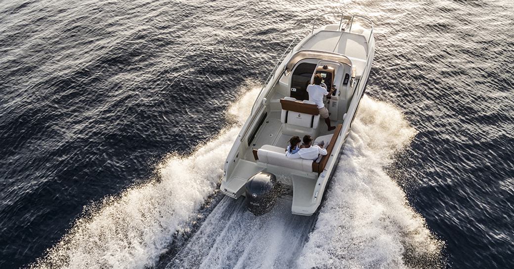 Invictus Yacht viewed from behind, moving at speed on water