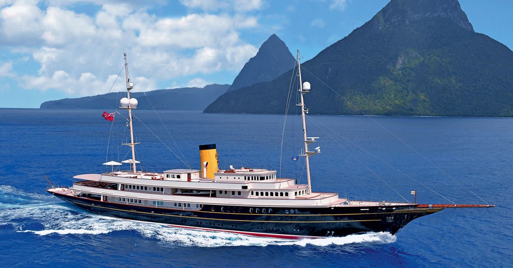 Superyacht NERO underway, surrounded by sea and mountains in background.