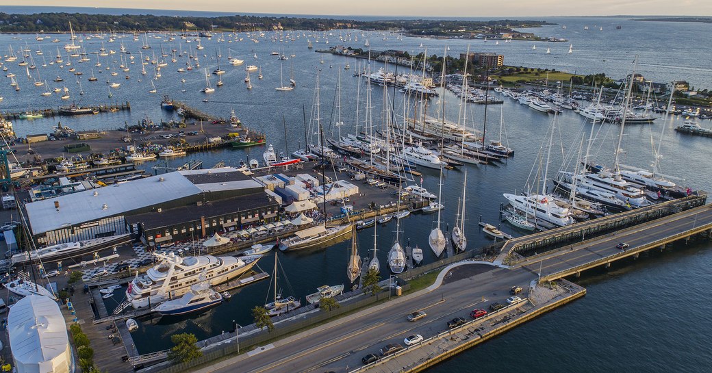 Elevated view of Safe Harbor Newport Shipyard, with multiple yachts moored, surrounded by sea