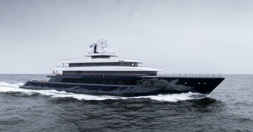 DRIZZLE Feadship superyacht shown in running shot, making way in moderate sea on grey day, starboard side profile shown