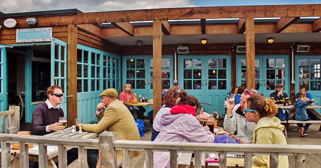 Visitors at the British Motor Yacht Show having drinks at one of the eateries around the marina.