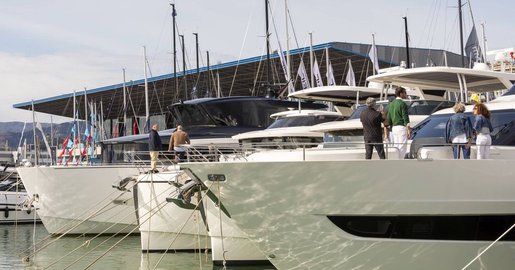 Yachts on show at Genoa International Boat Show, bows of boats moored against the building