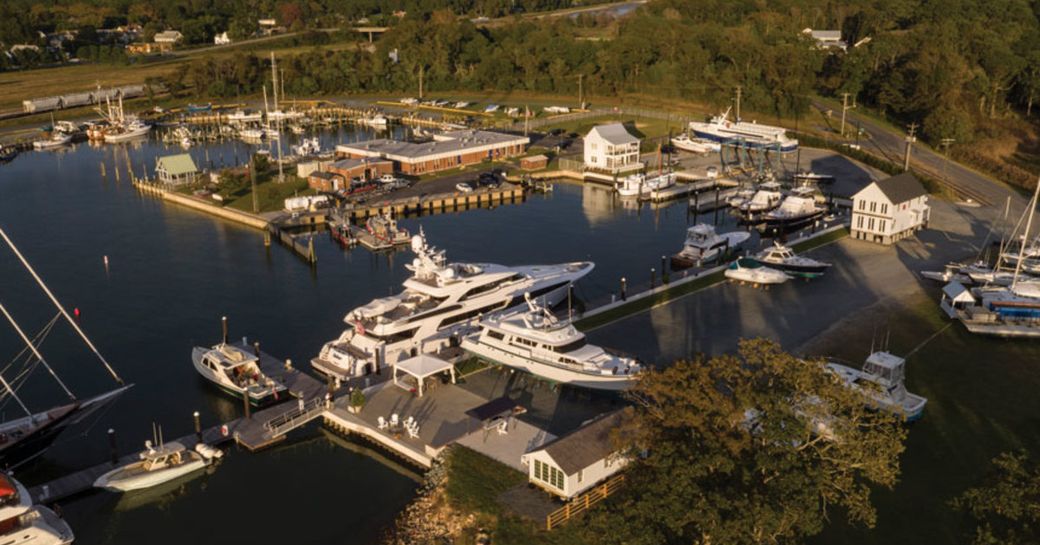 Elevated view of Cape Charles Yachting Center, yachts moored, surrounded by green foliage and river