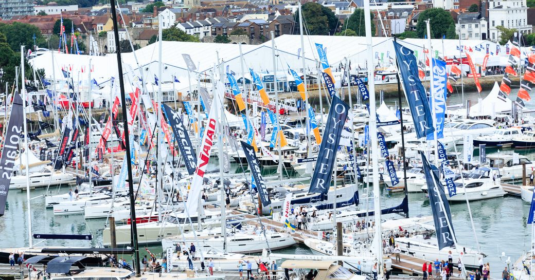 Overview of Mayflower Park Southampton during Southampton Boat Show. Many sailing boats and motor yachts berthed with flags.