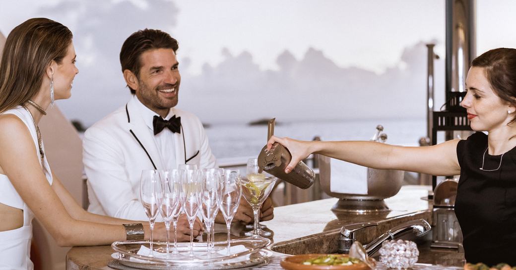 Stewardess pouring cocktails for charter guests