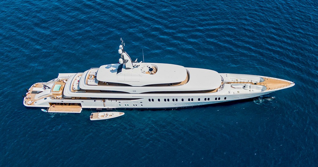 Side view of megayacht IJE at anchor with a tender alongside. Surrounded by sea.