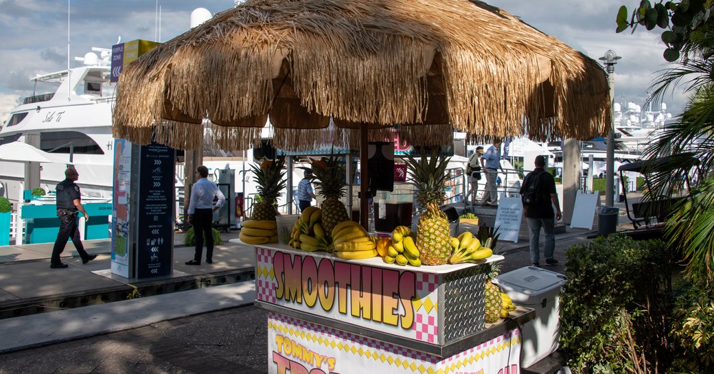 Smoothie stand at Fort Lauderdale International Boat Show, superyacht berthed in background.