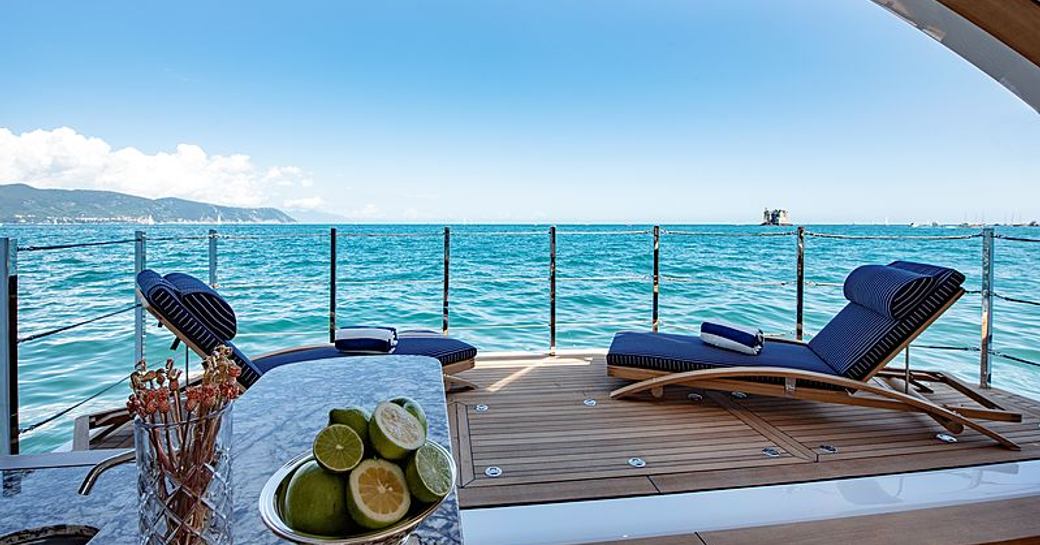 Side balcony onboard Sanlorenzo Lady Lena, with two sunloungers and a wetbar in port corner, overlooking sea