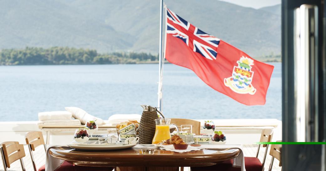 red ensign on aft deck with table laid for breakfast