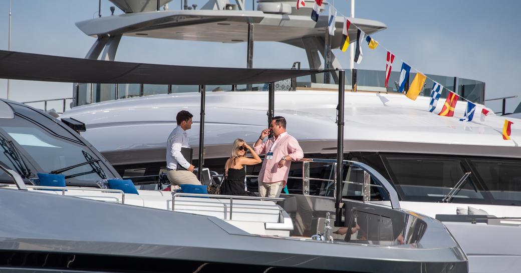 Visitors to the Monaco Yacht Show standing on deck with a representative during a tour.