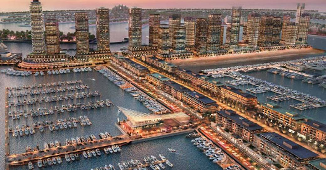 Elevated view of Dubai Harbour Marina, many yachts berthed, surrounded by sea and hotels at sunset