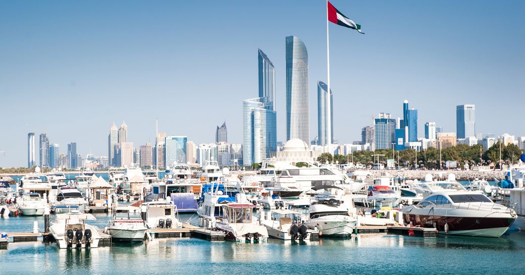 Motor yachts berthed in Abu Dhabi marina, skyscrapers visible in background