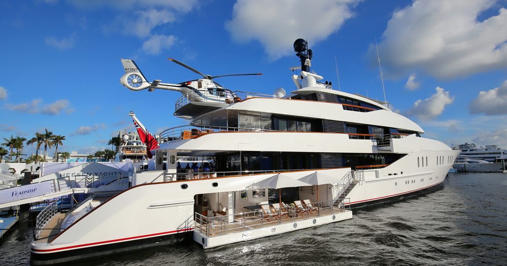 Superyacht moored at FLIBS with side terrace folded down and helicopter positioned on the helipad.