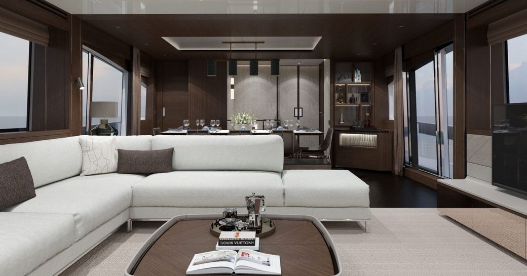 Elegant interior on Sunseeker 88 Yacht with L-shaped sofa and formal dining table behind