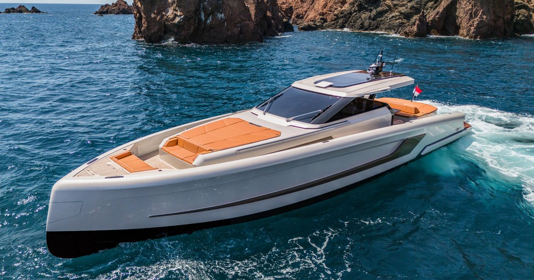 WiLder 60 boat floating in front of rocks in a calm sea