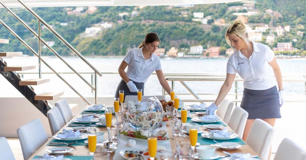 Two female crew members laying out table