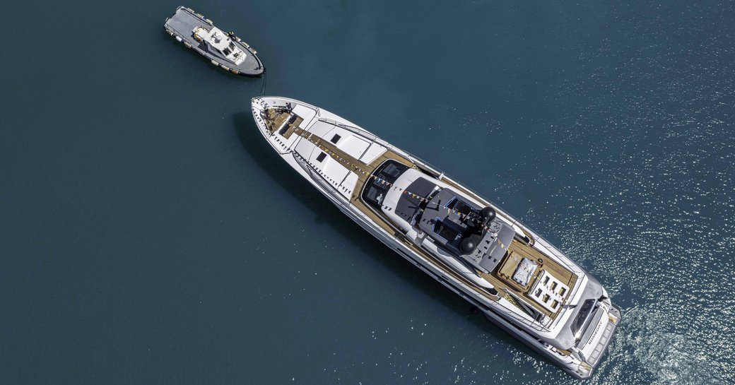 Aerial bird's eye view of M/Y SOMEDAY, surrounded by sea with a tender facing her bow.