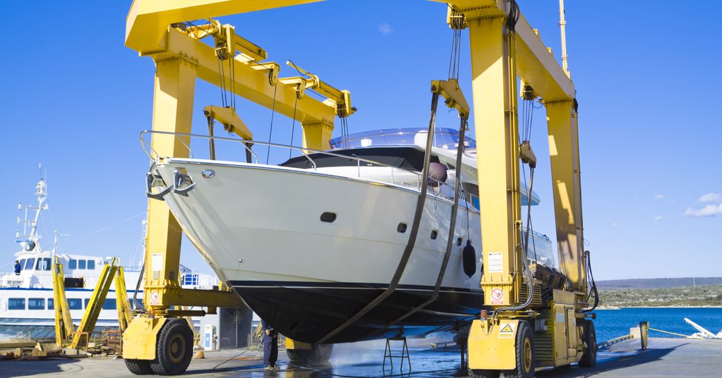 yacht being moved by a crane