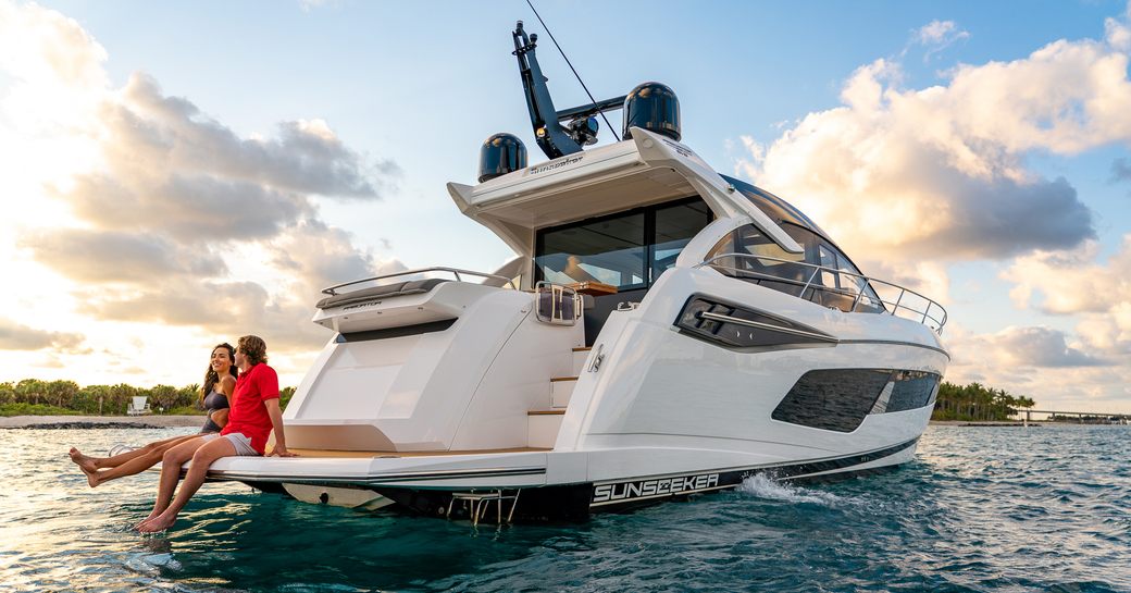 Couple sat on swim platform of Predator 55 EVO