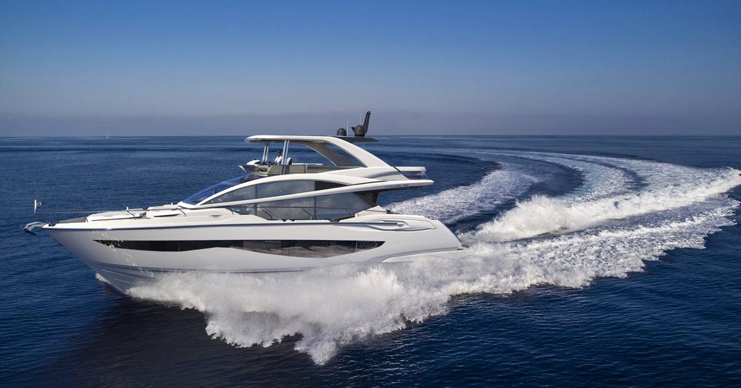 Pearl 62 superyacht being driven fast on sea at speed with clear blue sky in background and spray trail behind yacht