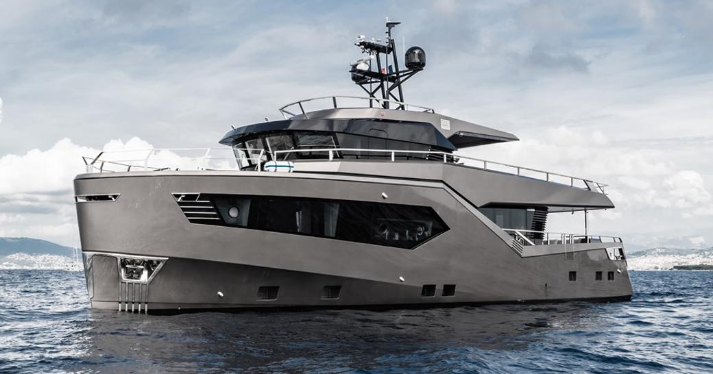 ROCK X by Evadne Yachts shown from water level towards port bow and side profile, in calm waters on bright but cloudy day