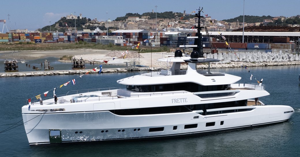 FRETTE Columbus Atlantique 43 on launch day with flags adorning yacht as she is pulled by tugs along calm waters, reasonably bright day