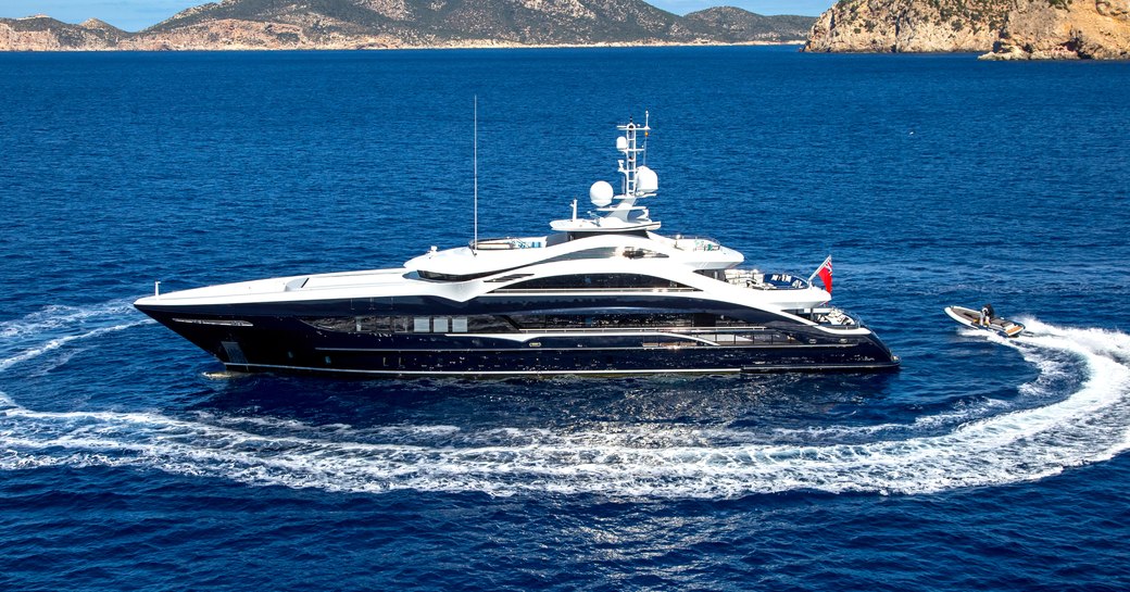 Superyacht on clear water with coast in background