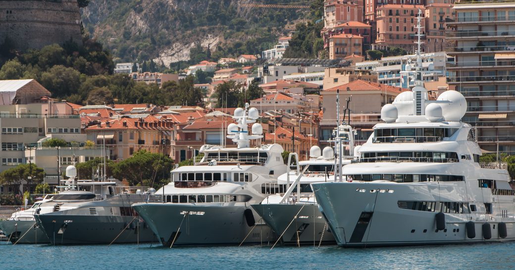 Motor yachts moored at Port Hercule, Monaco. Buildings visible in background.