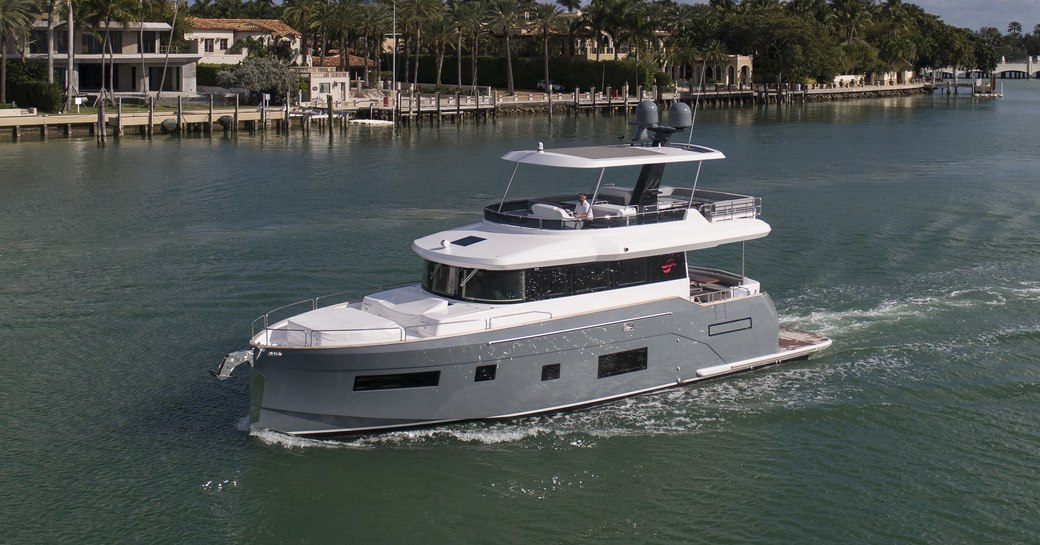 Side view of Sirena 58 underway, passing coastline villas in the US.