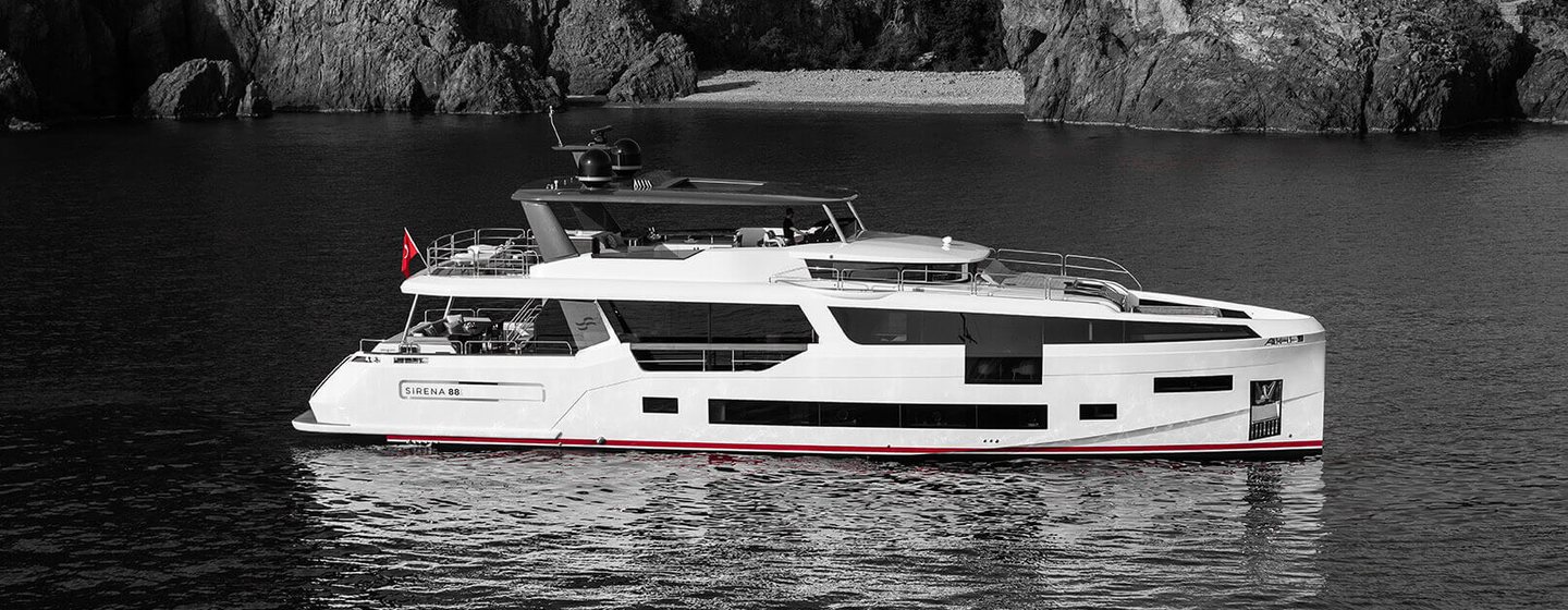 Sirena Yachts 88 at anchor, surrounded by sea and cliffs in background