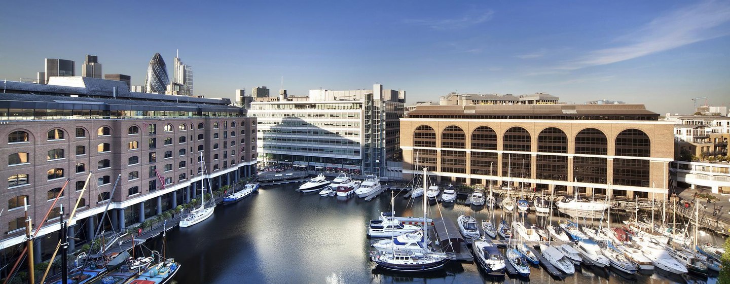 Overview of St Katharine Docks, motoryachts docked in centre, surrounded by marina facilities