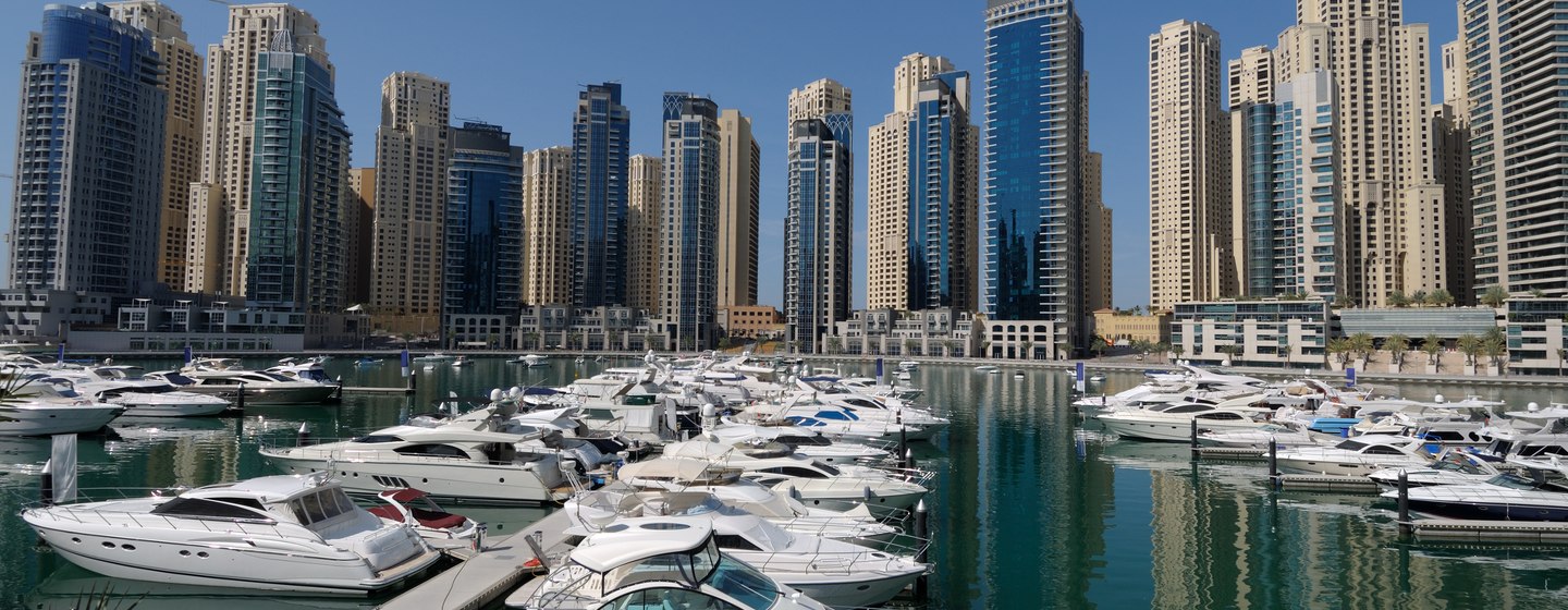 Motoryachts moored in Dubai Marina, surrounded by cosmpolitan skyline