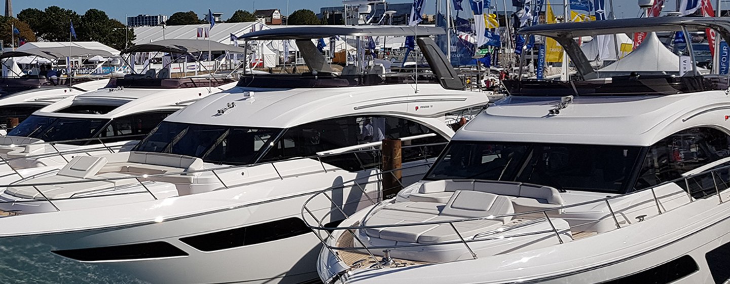 Motoryachts lined up for Southampton International Boat Show under a blue sky