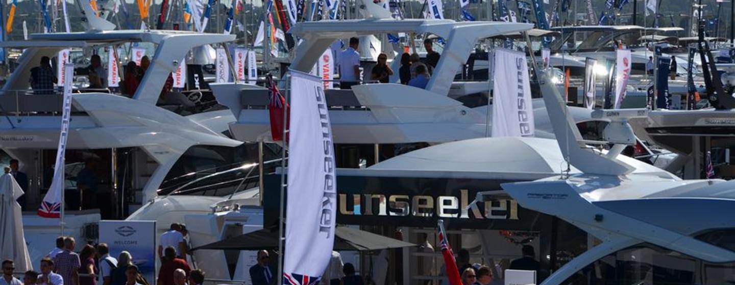 Southampton International Boat Show photo showing flags flying above yachts of all descriptions, Sunseeker stand in foreground