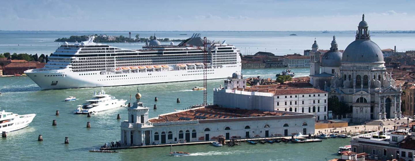 Cruise ship and motoryachts cruising in to Venice harbour, surrounded by Venetian architecture and sea