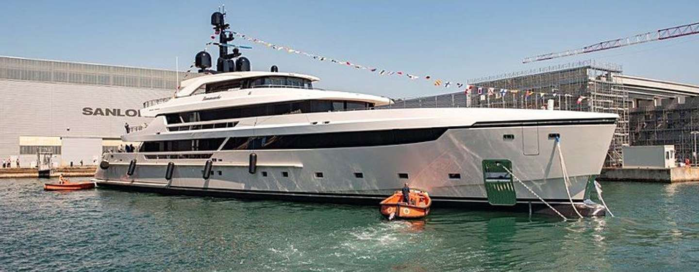 Side angle of Sanlorenzo LAMMOUCHE in dock, surrounded by shipyard buildings and sea