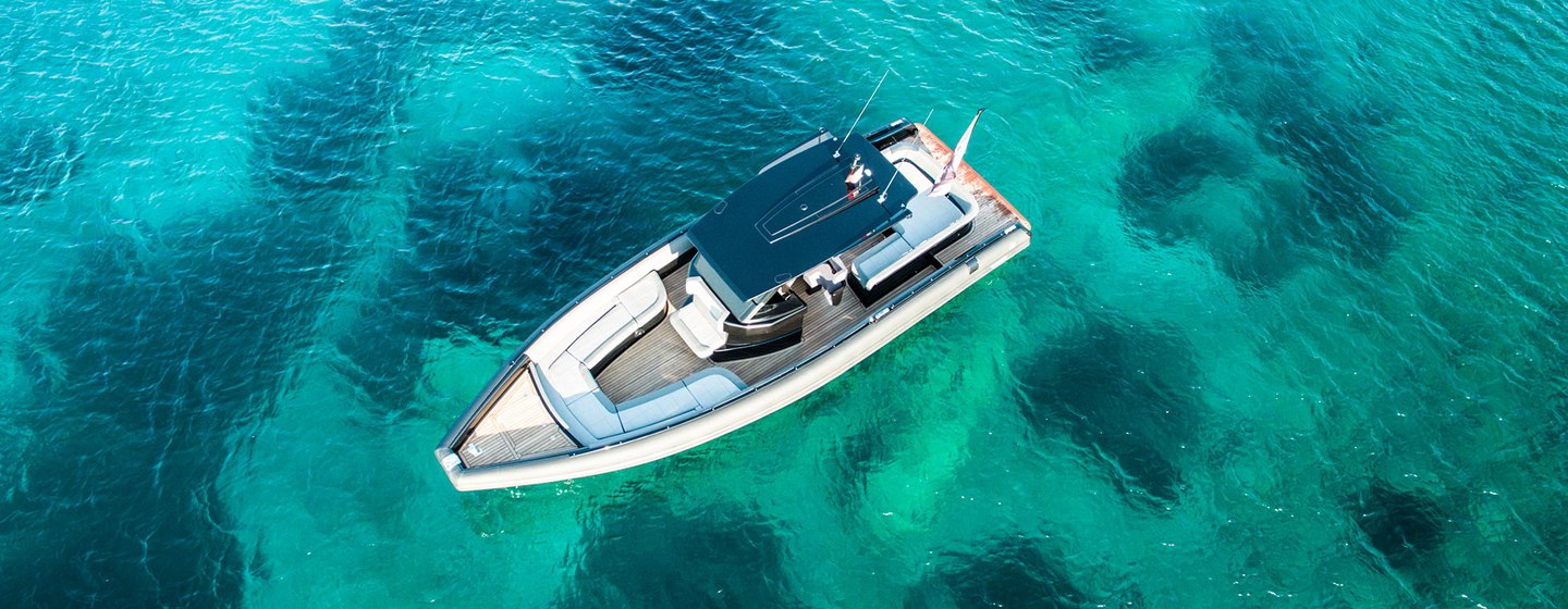 Chase boat viewed from above on clear water with reefs visible below