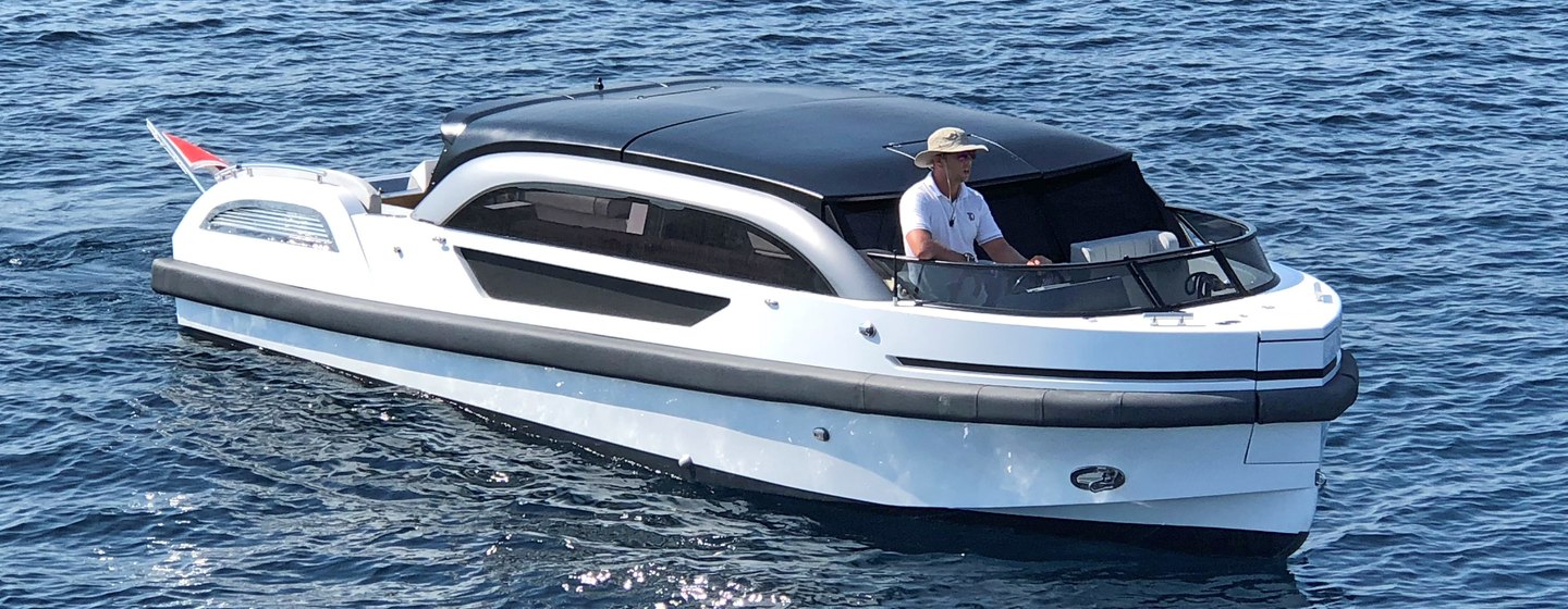 Limousine tender with man at helm on calm water