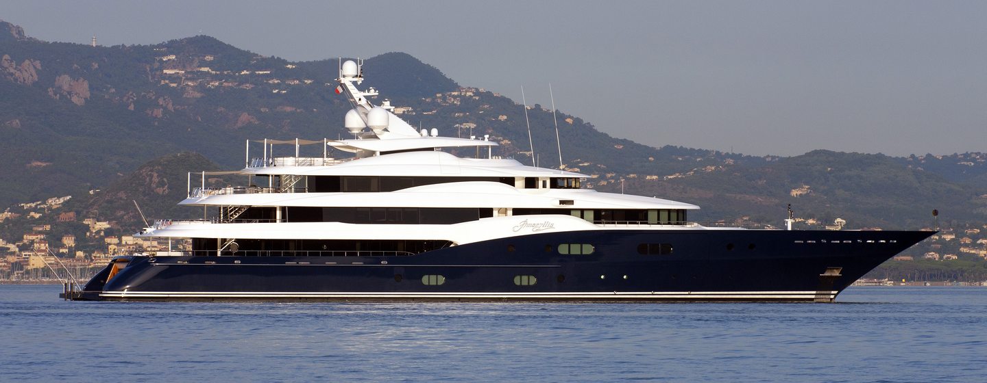 Superyacht AMARYLLIS underway, surrounded by sea and land in distance