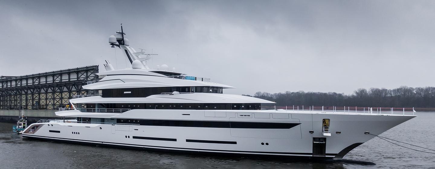 Side view of Lurssen 'Project Hawaii' leaving dock, surrounded by grey skies and sea