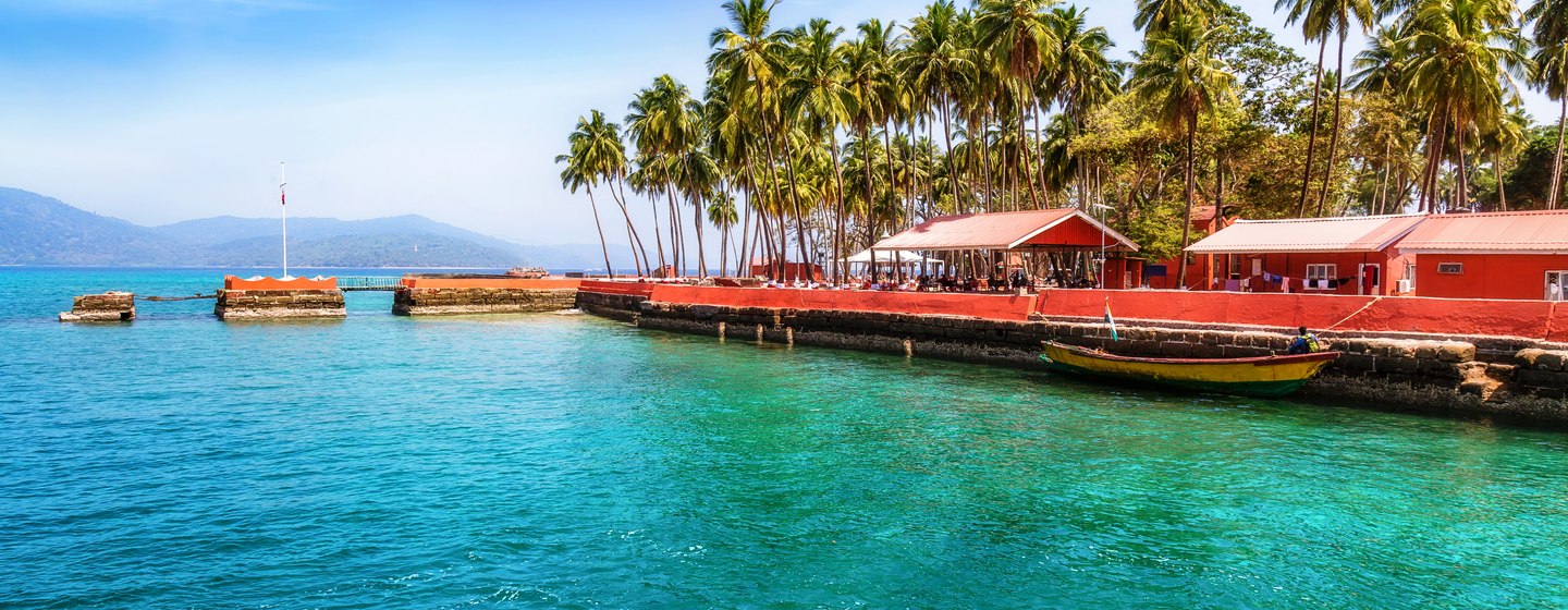 Ross Bay in the Andaman Islands, red tents by dock, surrounded by palms and sea