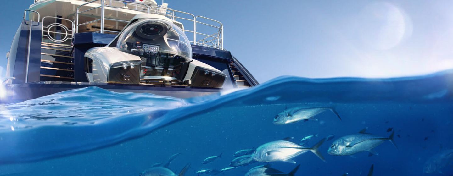 NEMO submarine aft of a superyacht awaiting launch, surrounded by sea with glimpse of fish in foreground