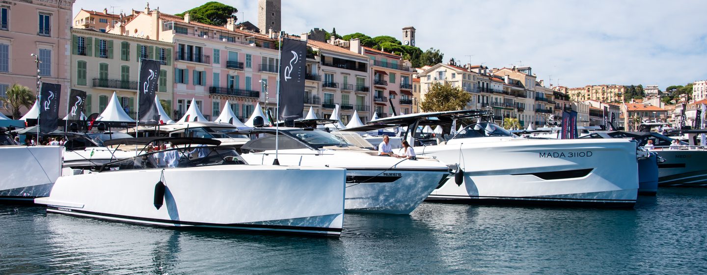 shot taken at Cannes Yachting Festival 2024 of motor cruisers moored stern to against dock, bright day