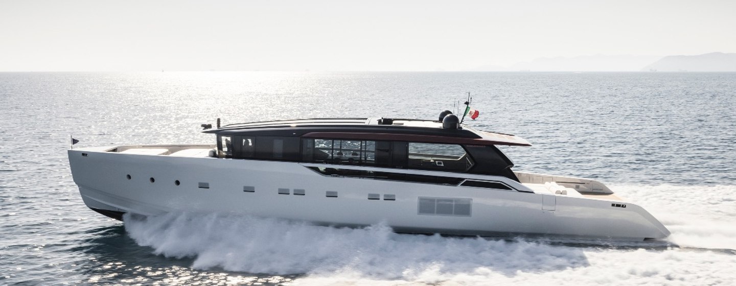 Sanlorenzo SP110 motor yacht running shot at speed in calm water on clear day, port side profile shown from mid arial over water